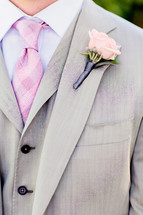 Mans grey suit with pink checker tie pink rose boutonnière 