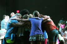 embracing in a prayer circle