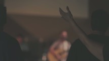 Audience with arms raised at a worship concert.