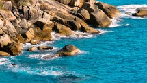 Aerial Top view of a transparent blue sea with beautiful waves. Aerial view seashore cliffs wave crashing on rocks