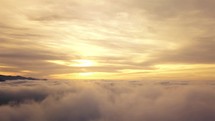 Aerial view of misty clouds at sunrise.
