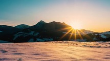 Sun is going down in beautiful winter nature scenery at sunset in cold snowy mountains landscape Time lapse
