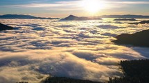 Beautiful sunrise over wild forest mountains hidden in foggy clouds in sunny morning nature Time Lapse
