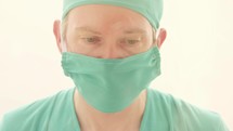 surgeon with a surgical mask and scrubs