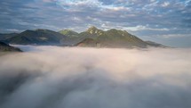 Magic fly above clouds in green mountains
