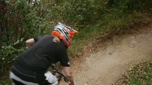 a man in a helmet riding a bike on a dirt trail 
