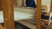 Man weaving in a textile workshop using a hand loom