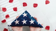 Holding USA Flag Folded Into A Triangle