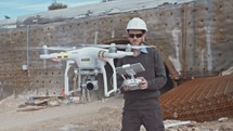 Man flying a drone for construction survey in a large highway construction site