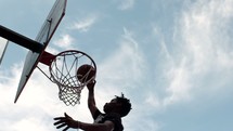 an African American man dunking a basketball 