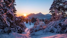 Colorful sunrise over snowy alps mountain in peaceful winter nature forest landscape morning time lapse dolly shot
