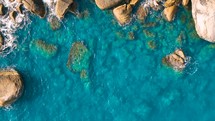 Aerial Top view of a transparent blue sea with beautiful waves. Aerial view seashore cliffs wave crashing on rocks