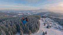 Paraglider flying above winter alps countryside nature, paragliding follow camera
