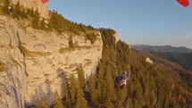 Paragliding proximity flying freedom by rocks and forest in mountains nature

