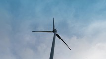 Wind turbine with blue clouds background