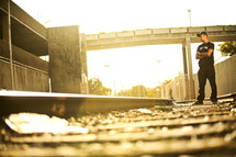 Man standing on empty train tracks