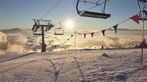 Magic sunny winter morning in mountains ski resort with empty chairlift starting in new day
