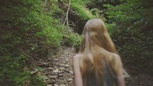 woman walking up a mountain trail 