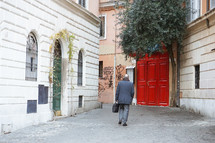 a businessman carrying a briefcase walking down an alley 