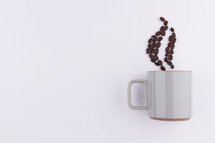 coffee beans in the shape of steam from a mug on a white background 