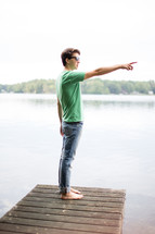 man on a dock pointing 
