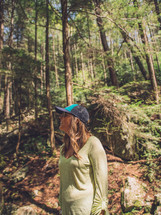a woman standing alone in a forest 