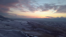Aerial view of evening sunset color over snowy fields
