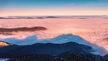 Time lapse of Foggy clouds motion like river in alps mountain nature at golden sunrise in sunny valley
