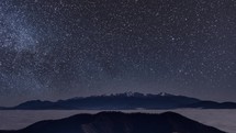 Milky way galaxy Starry night sky with stars over winter alps mountains Astronomy Time-lapse 
