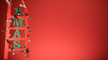 Christmas decoration ladder on red copy space background