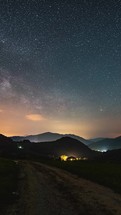Vertical video of milky way galaxy stars moving over countryside nature landscape astronomy timelapse
