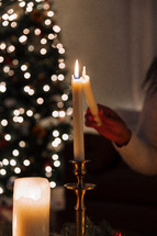 Person lighting a taper candle.