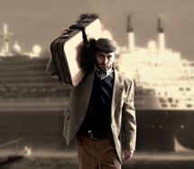 a man standing in front of a cruise ship carrying luggage 