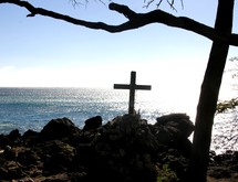 cross on a rocky cliff at the coast