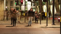 pedestrians and passing cars in a city at night - editorial use only
