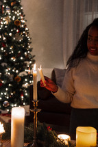 Woman lighting a taper candle.