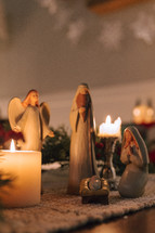 Nativity figures surrounded by candles.