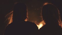 Silhouette of women in front of a campfire.
