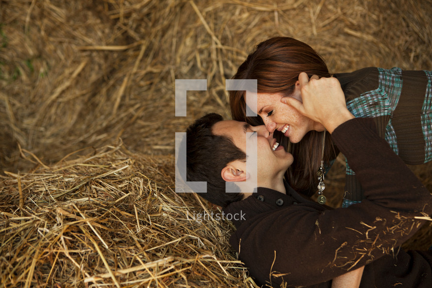 a couple kissing in hay