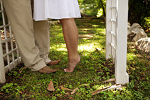 Barefoot woman on tip-toes standing to man with shoes