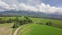 Fly above of fresh green landscape in spring alpine mountains nature
