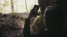 a woman filming a fall forest with her iPhone 