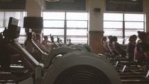 women using rowing machines in a gym 