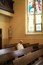 priest praying in a chapel