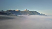 Fly above foggy clouds in sunny mountains
