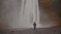 woman standing in front of a rushing waterfall 