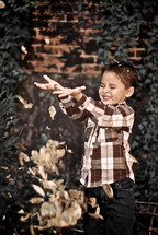 boy child tossing leaves
