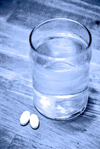 Medicine--a glass of water and two tablets.