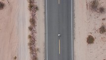 Man walking away in desert highway. A man walking on a road in the desert. 