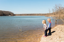kids skipping rocks on a riverbanks 